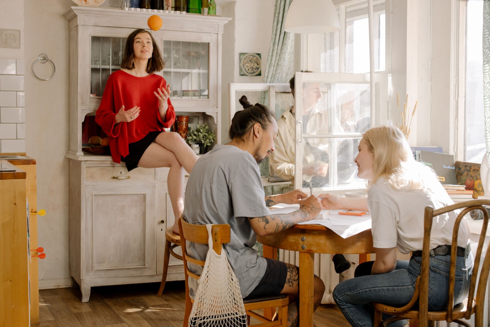 Students talking around the table of a sunny shared kitchen