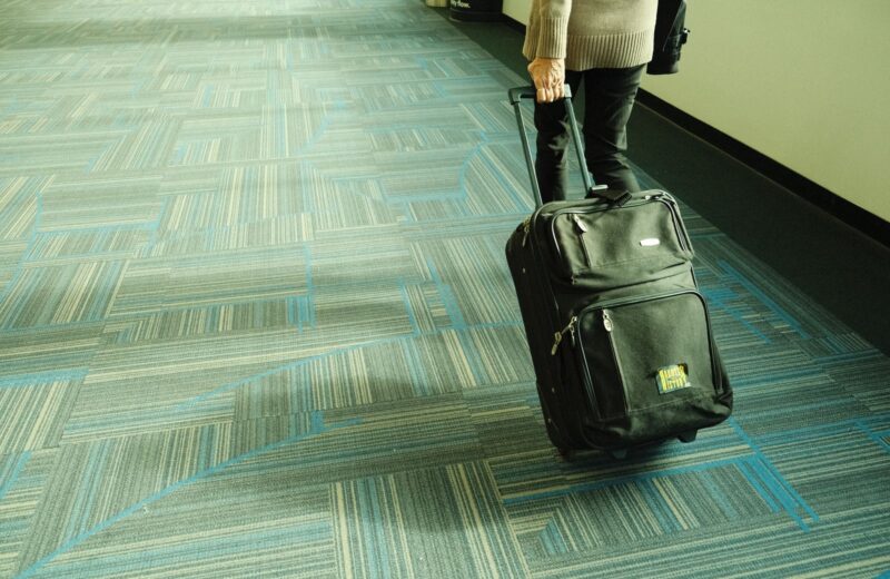 A traveller pulling a suitcase along an airport corridor