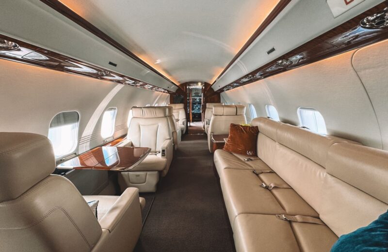 Leather club seats and a long sofa in a private jet cabin