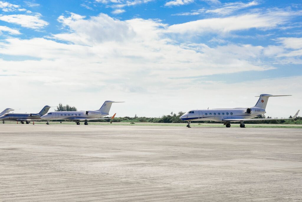 Business jets parked in a row on a quiet airfield