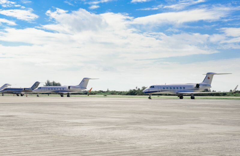 Business jets parked in a row on a quiet airfield