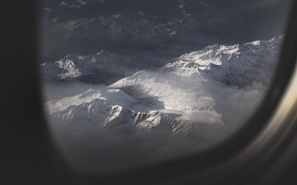 Snowy mountain peaks seen through an aircraft window