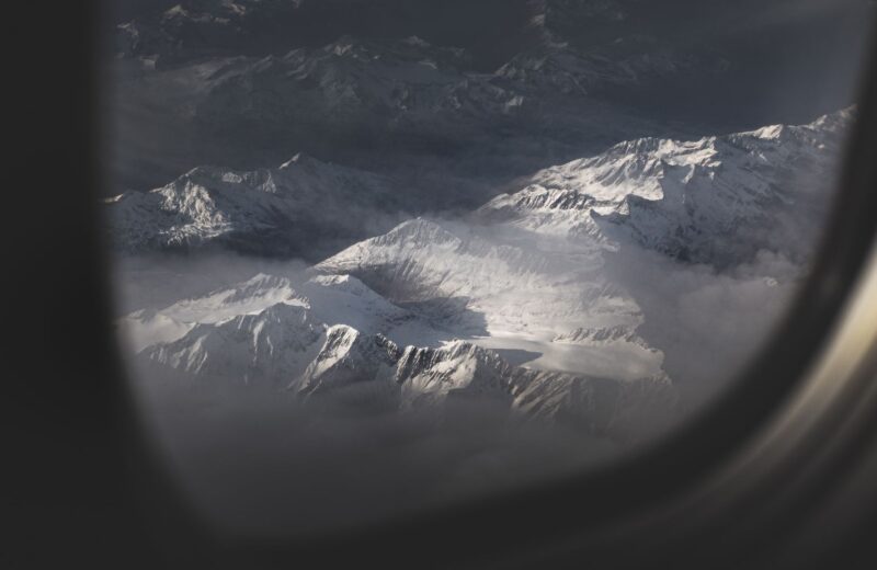 Snowy mountain peaks seen through an aircraft window