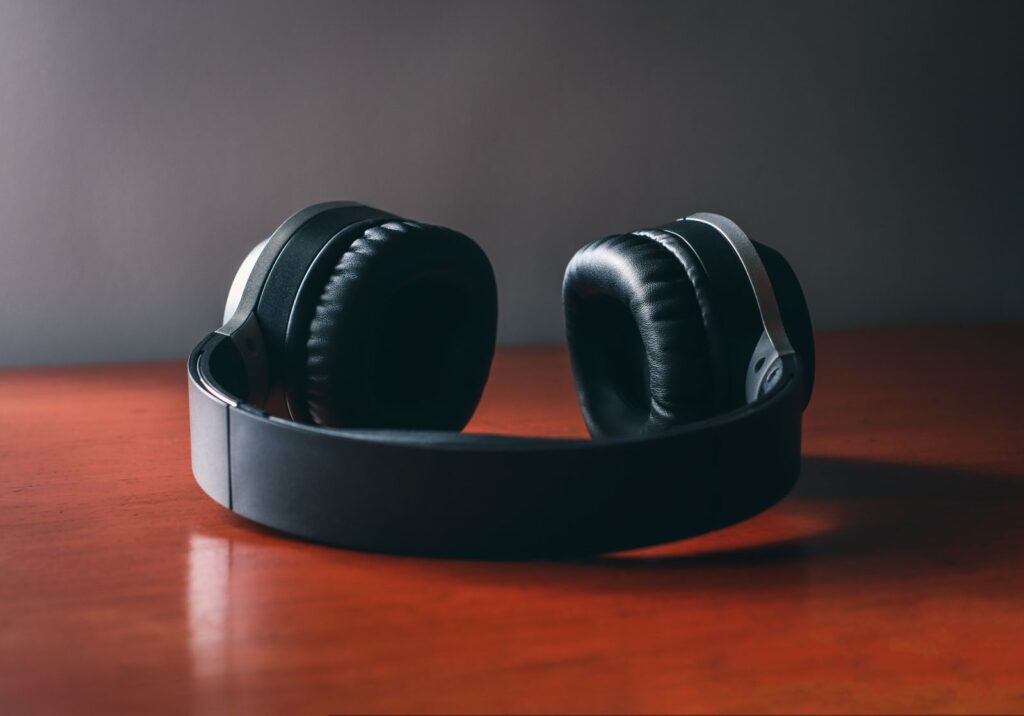A pair of closed-back headphones lying on a wooden table