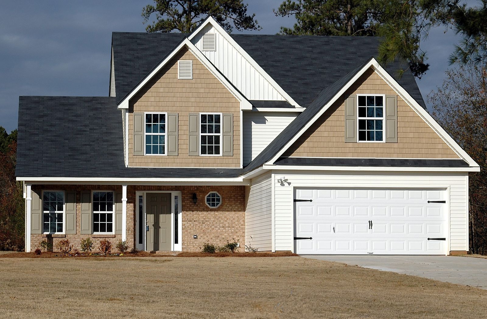 Two-storey house with a double garage, white trim and a dark shingle roof