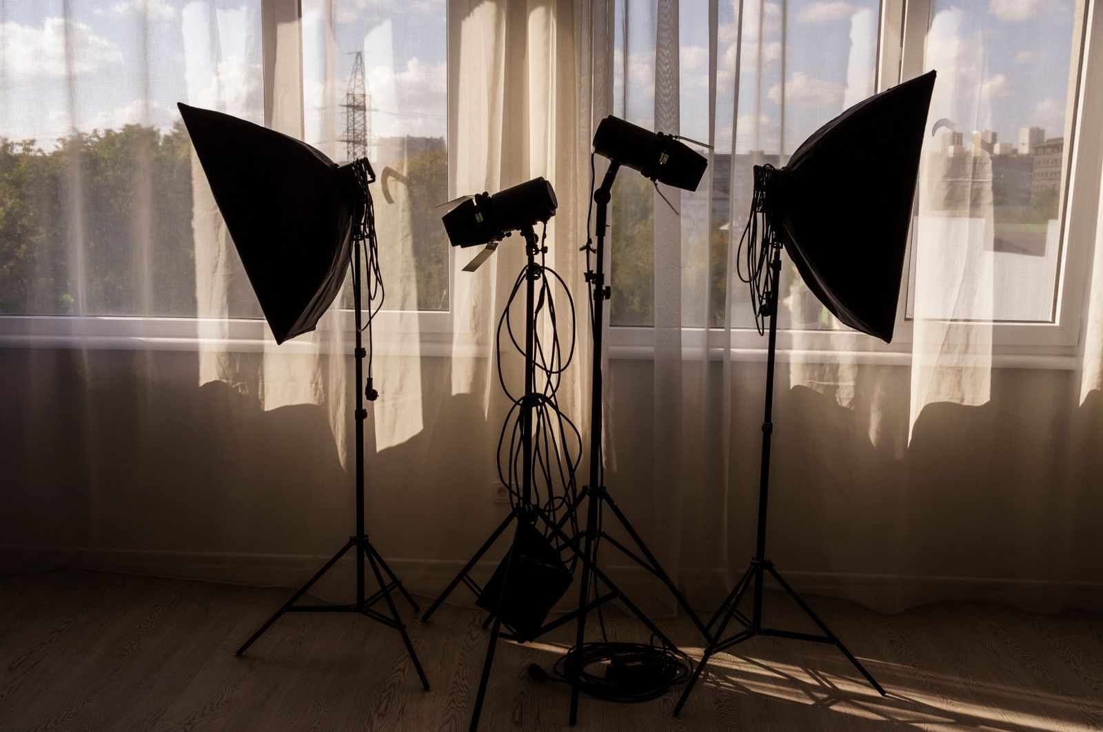 Softboxes and light stands in front of a curtained window