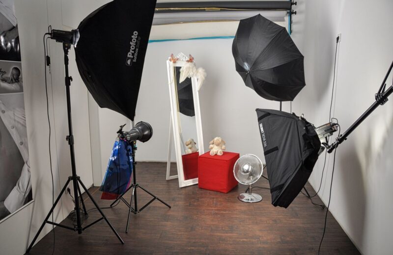 Studio set with softboxes, a mirror and props on a wooden floor
