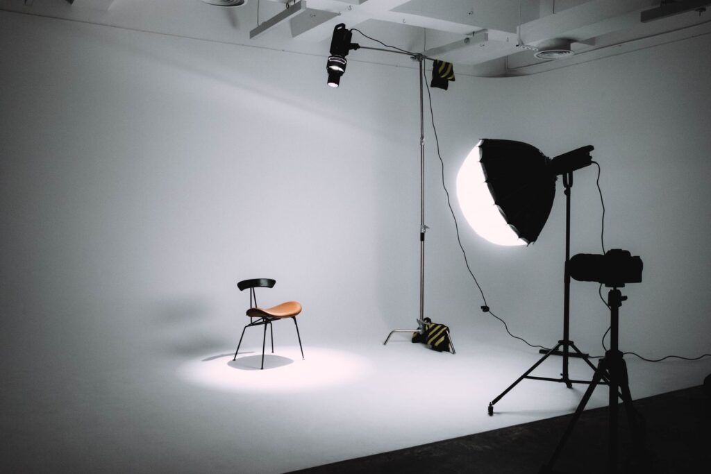 Empty studio with a chair on a white backdrop and lights around it