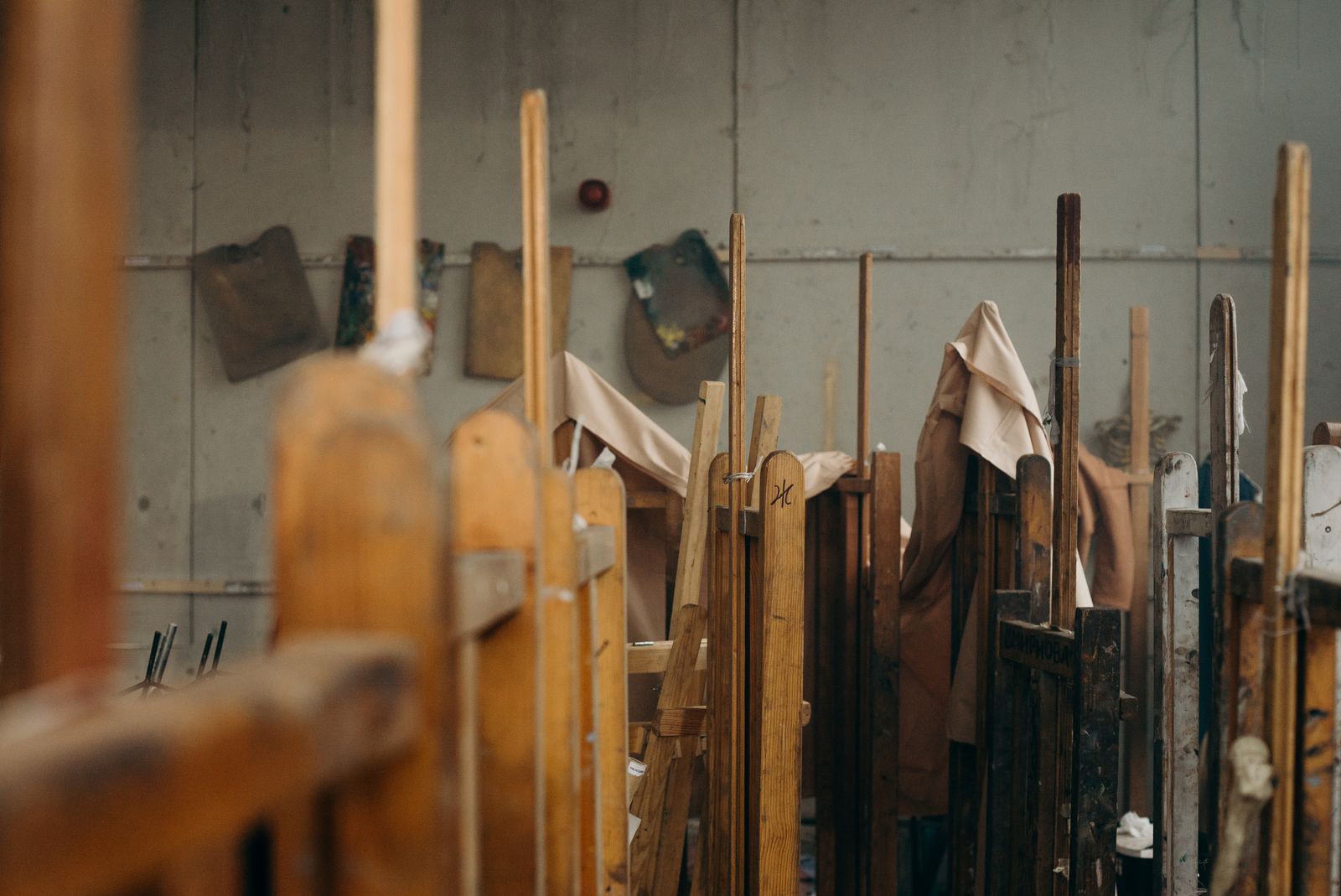Wooden easels and covered canvases standing in the studio