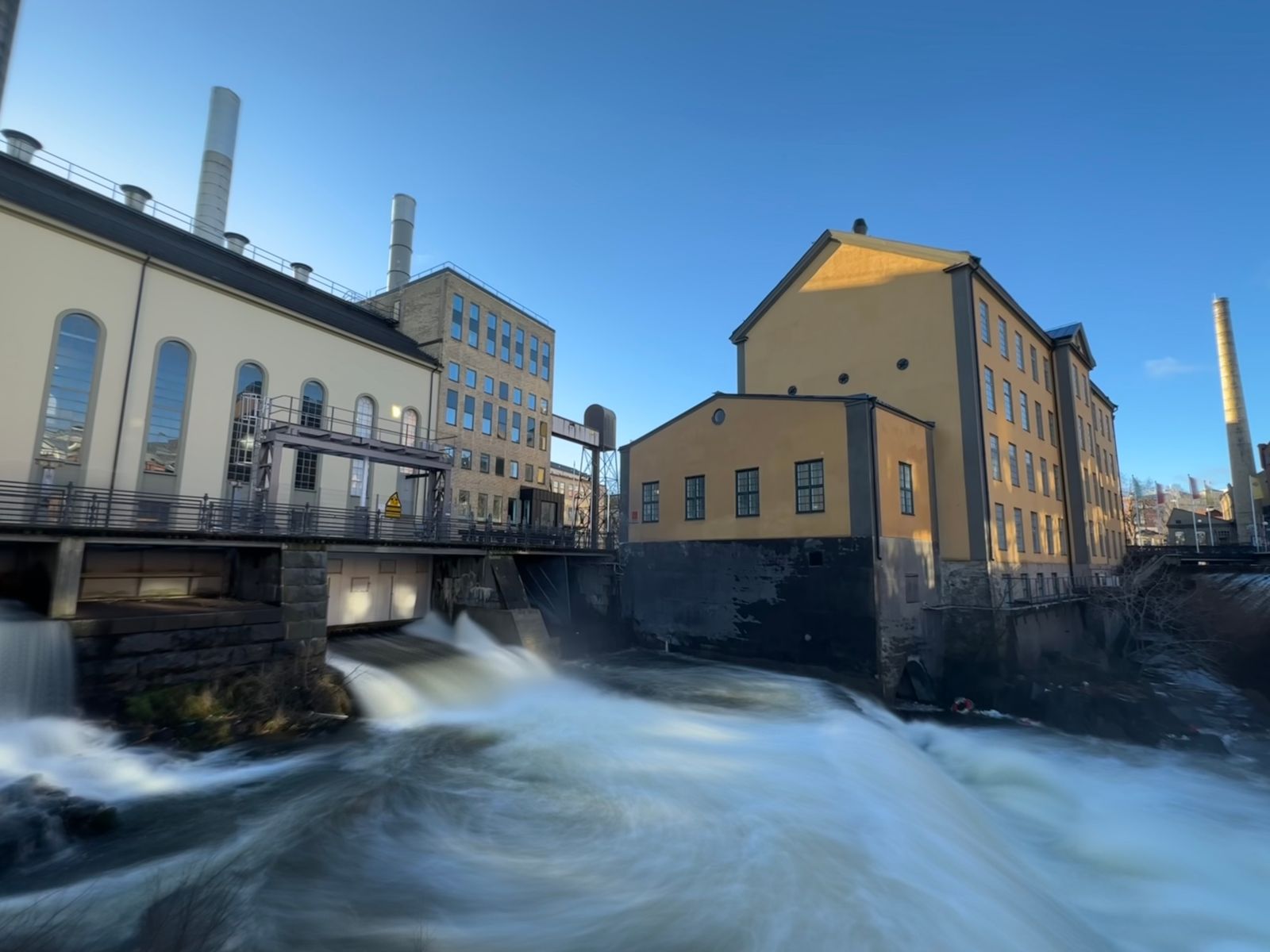 Old industrial buildings on the bank of a fast river