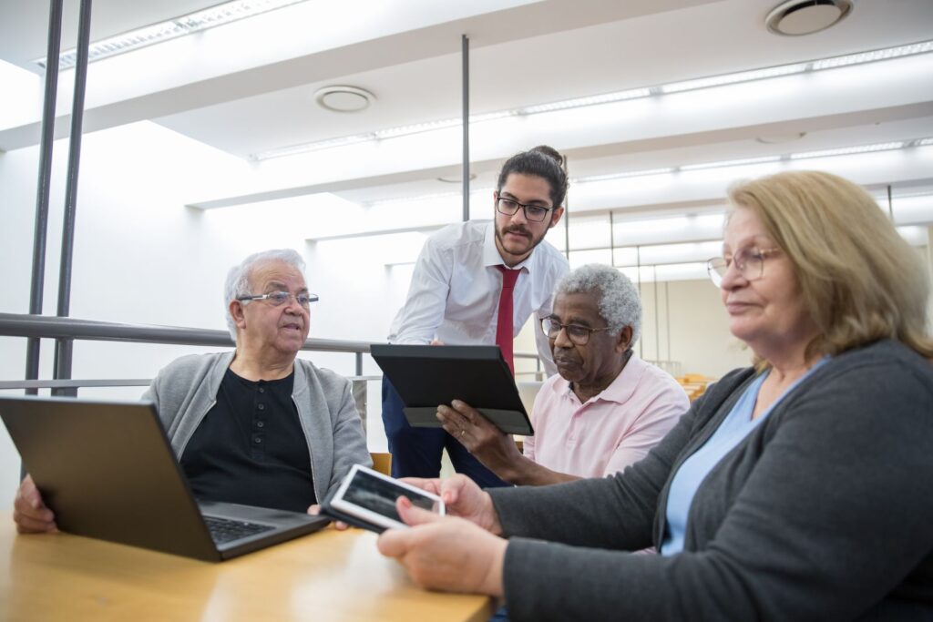 Older adults learning to use tablets and laptops at a library workshop