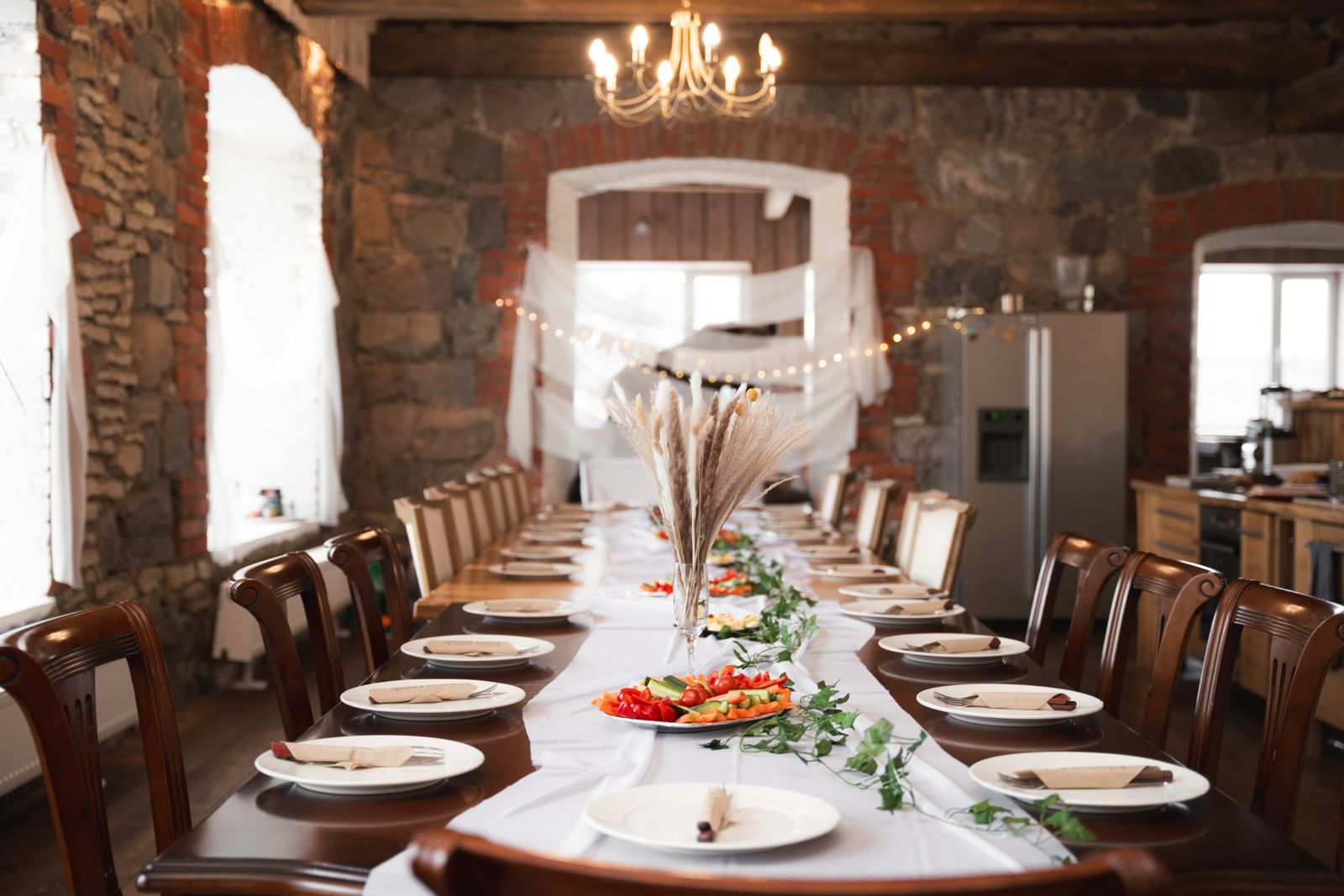 A long table laid for a party dinner in a stone-walled room