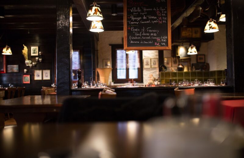A warm wood-panelled dining room with low lights in the evening