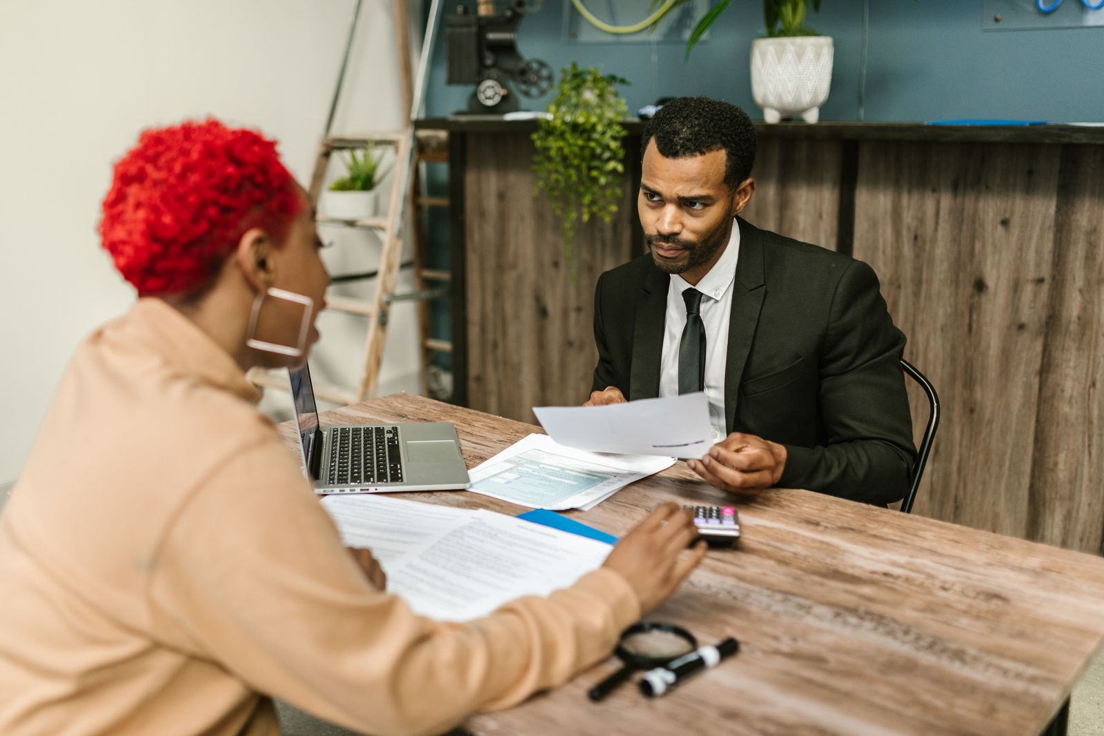 An adviser talking a client through paperwork at an office desk