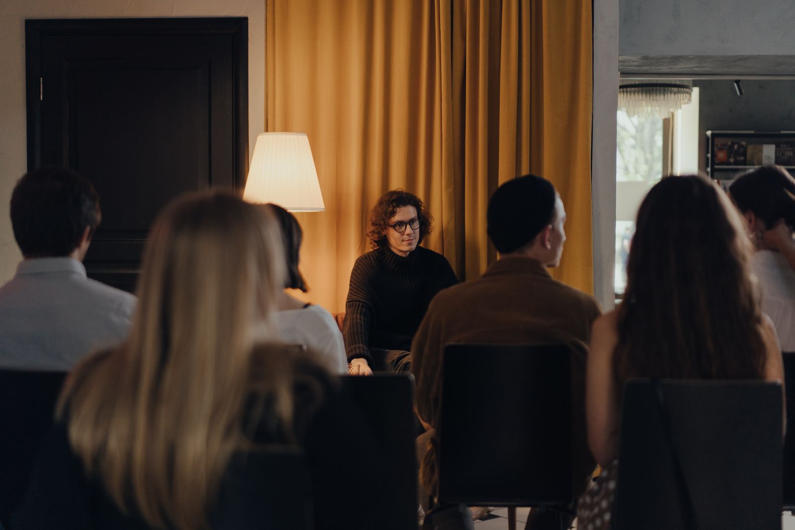 Audience seen from behind listening to a speaker in a small room