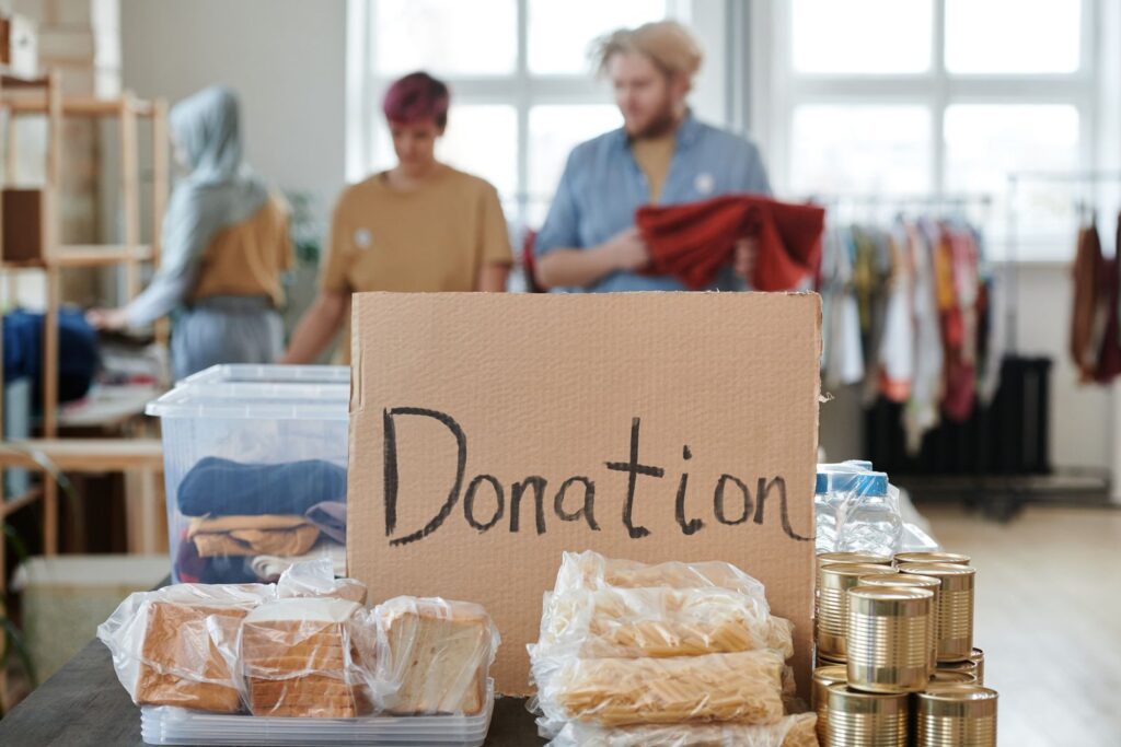 Volunteers behind a table with a handwritten donation sign