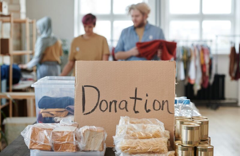 Volunteers behind a table with a handwritten donation sign