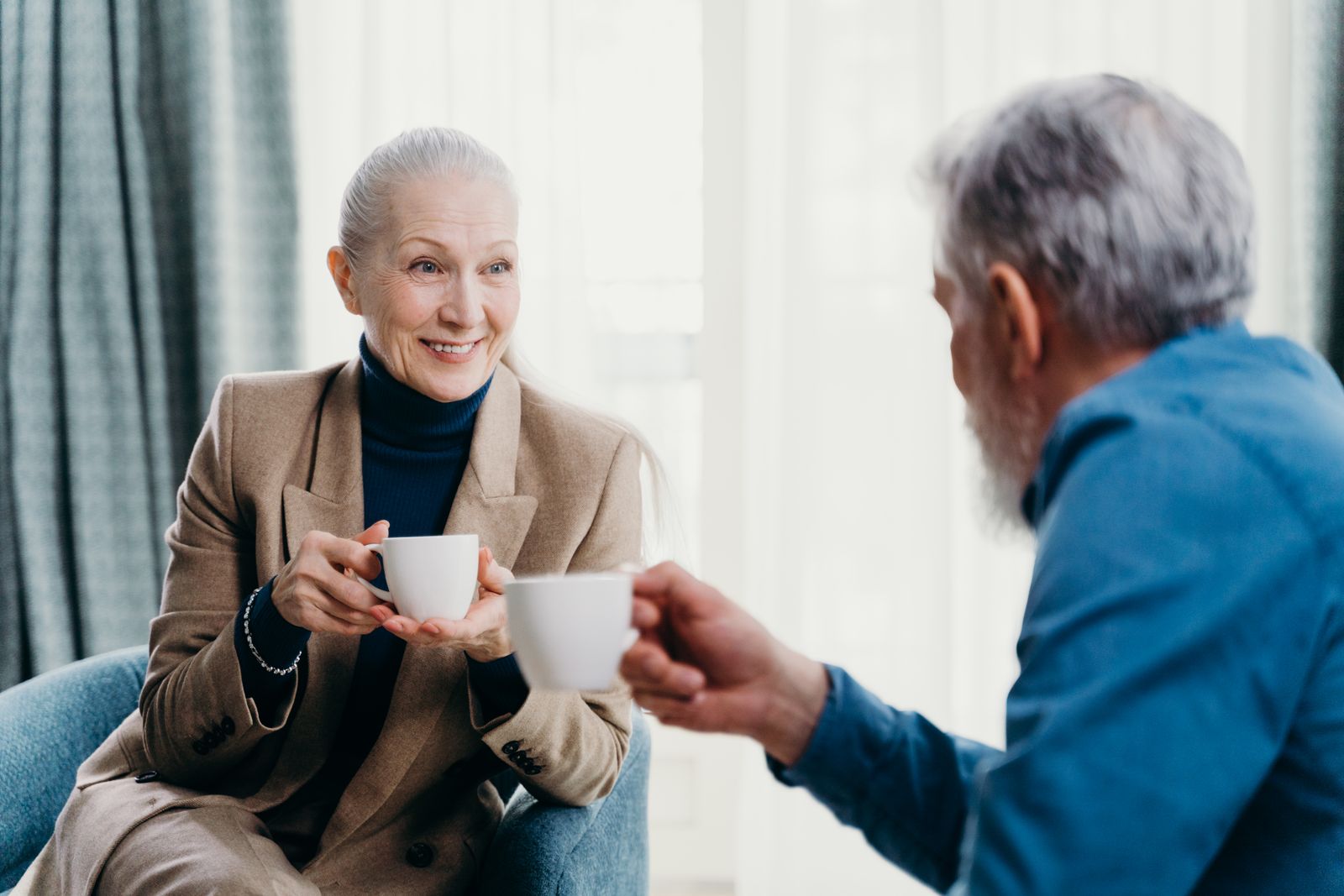 Two older people sharing a cup of tea at home