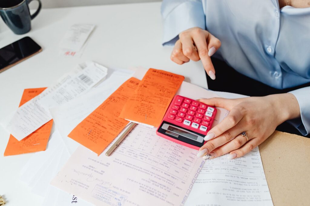 Receipts, a calculator and notes spread on a desk
