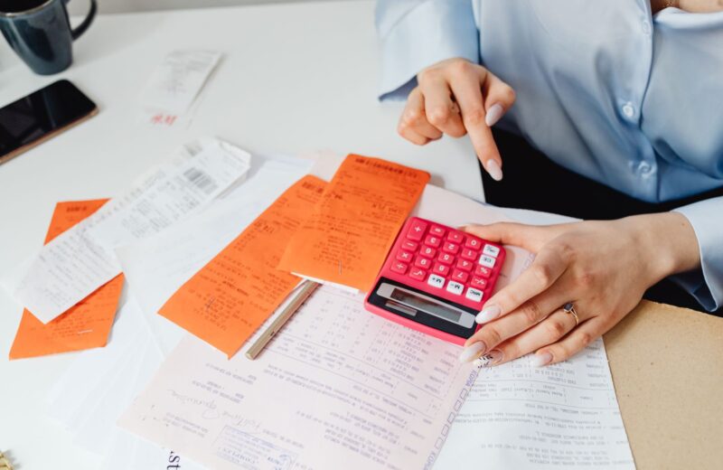 Receipts, a calculator and notes spread on a desk
