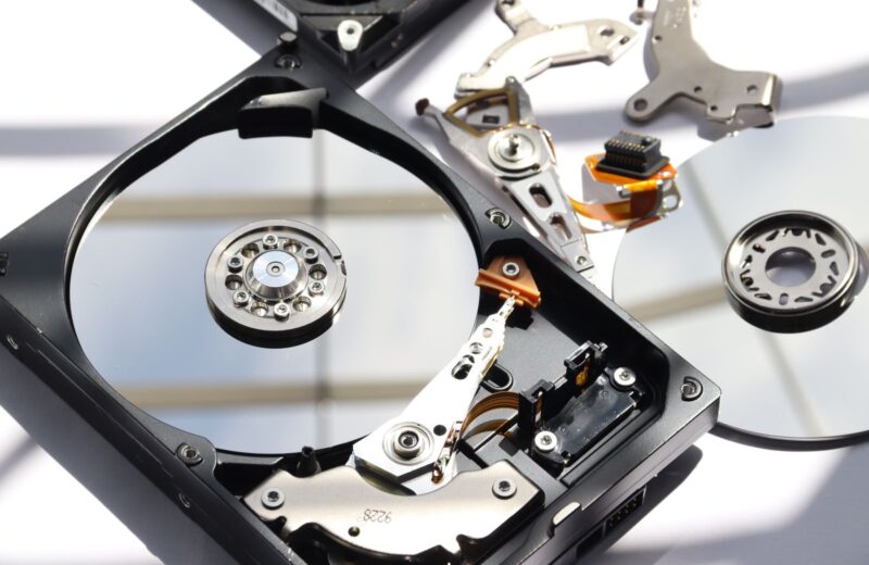 The inside of an opened hard drive: platter, arm and magnets