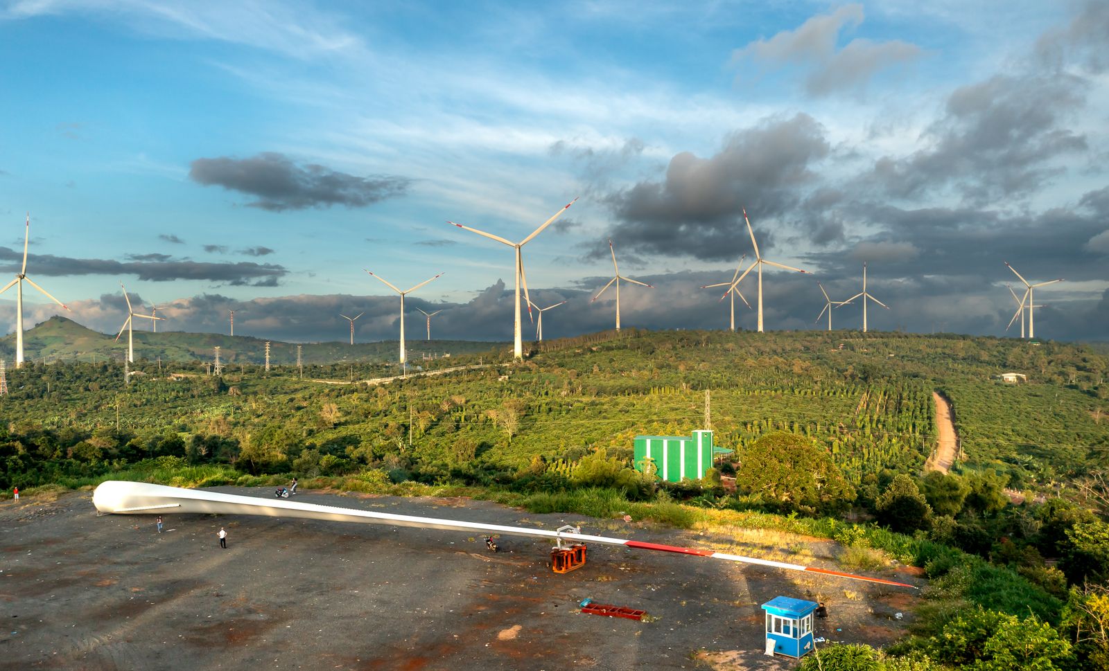 Wind turbines across green hills under a blue sky