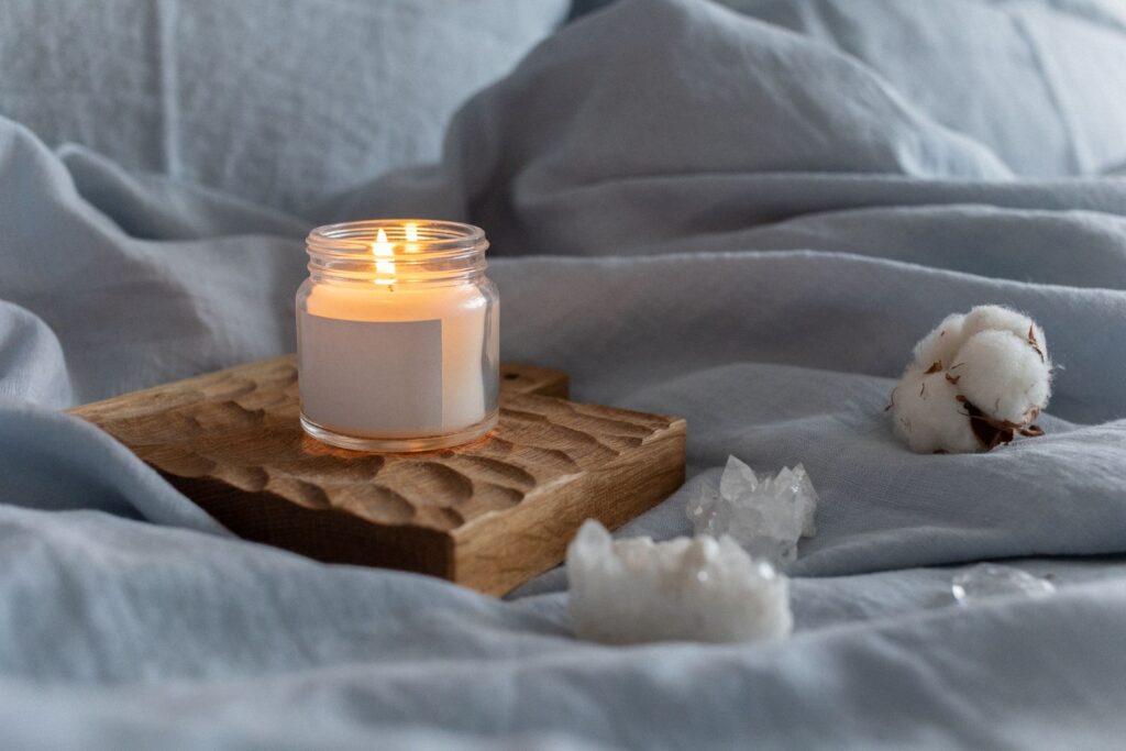 A lit candle on a carved wooden tray
