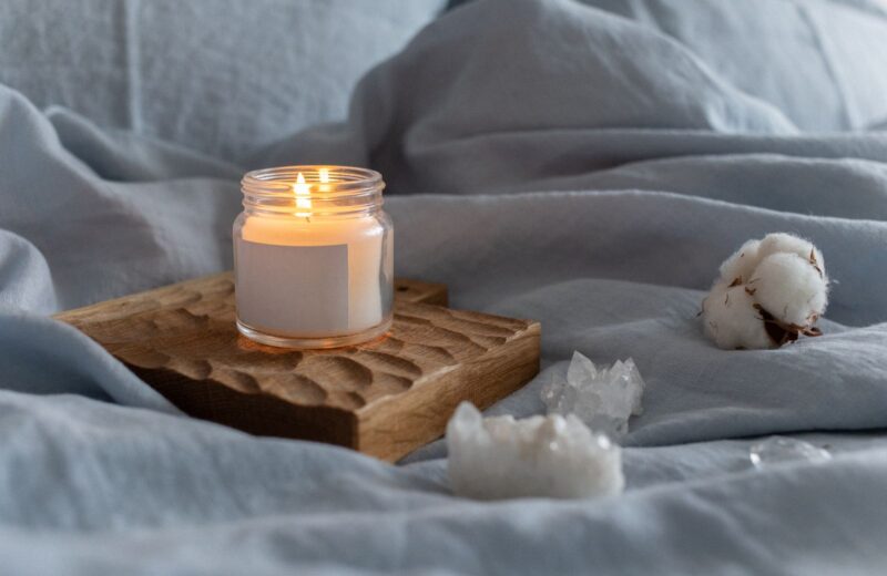 A lit candle on a carved wooden tray