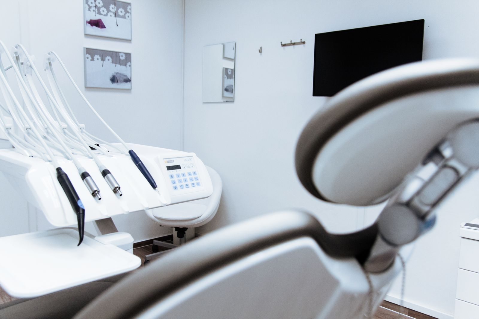 A bright, empty dental surgery with the chair, the light and the instrument arm