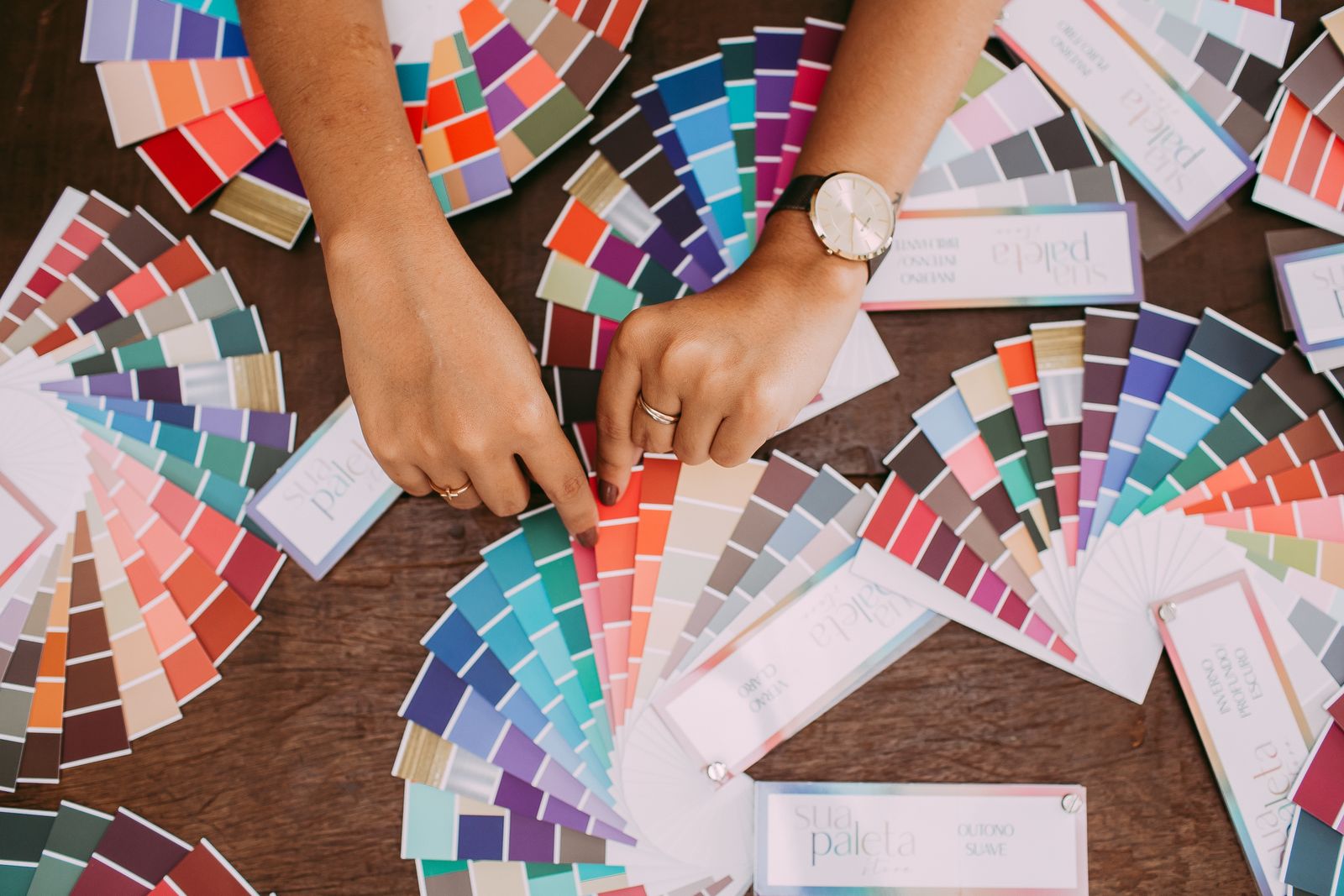 Hands spreading colour fan decks across a table