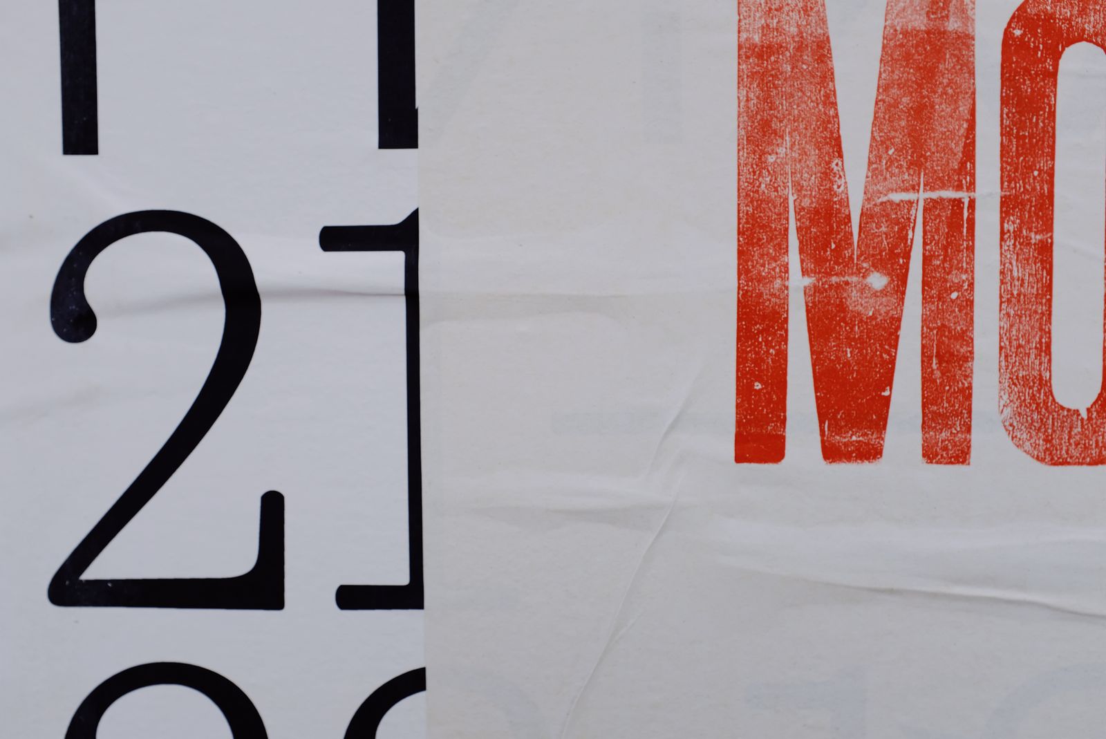 Large black letters and numbers printed on a white banner on a building