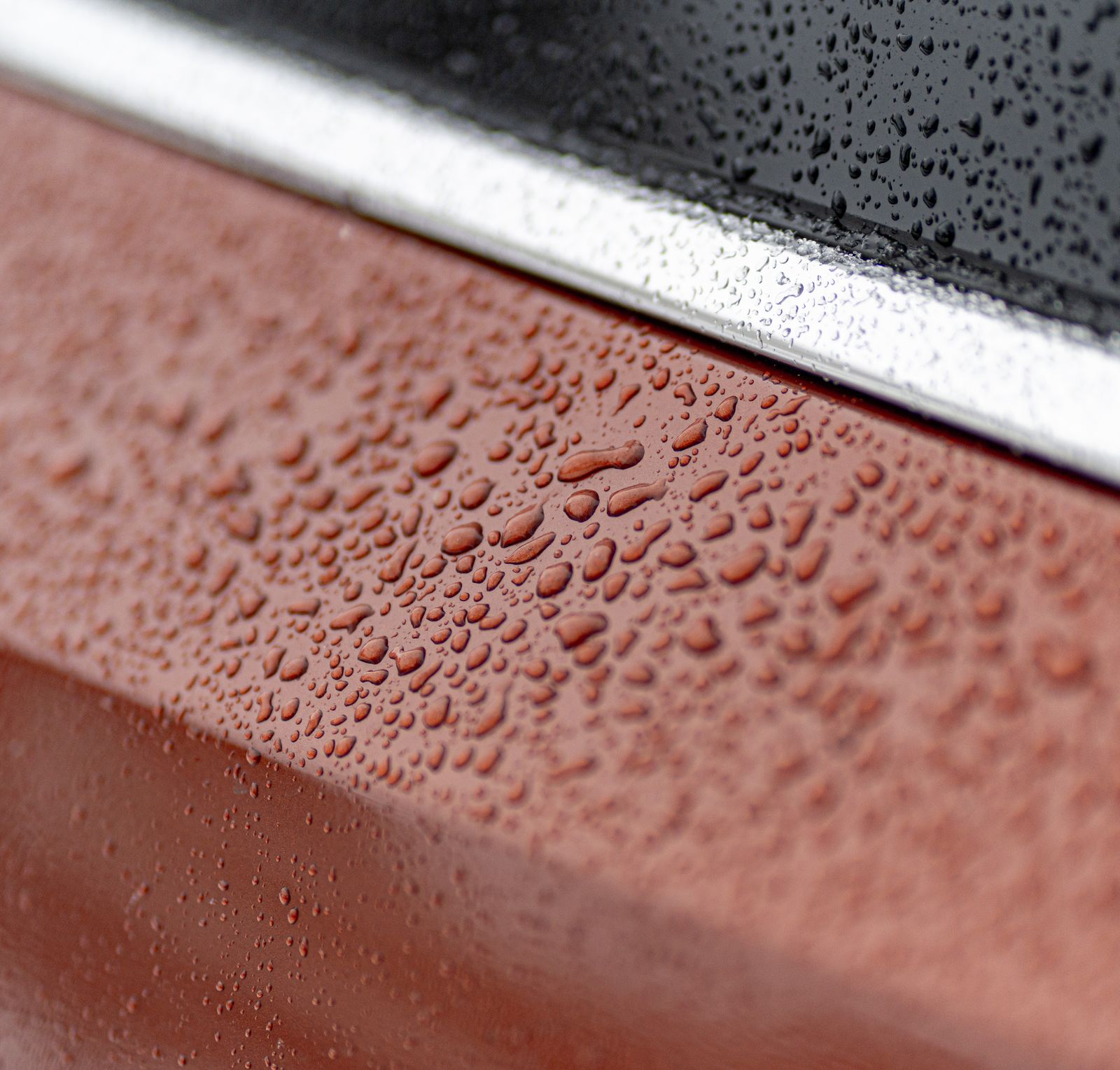 Water beading in tight drops on red paintwork