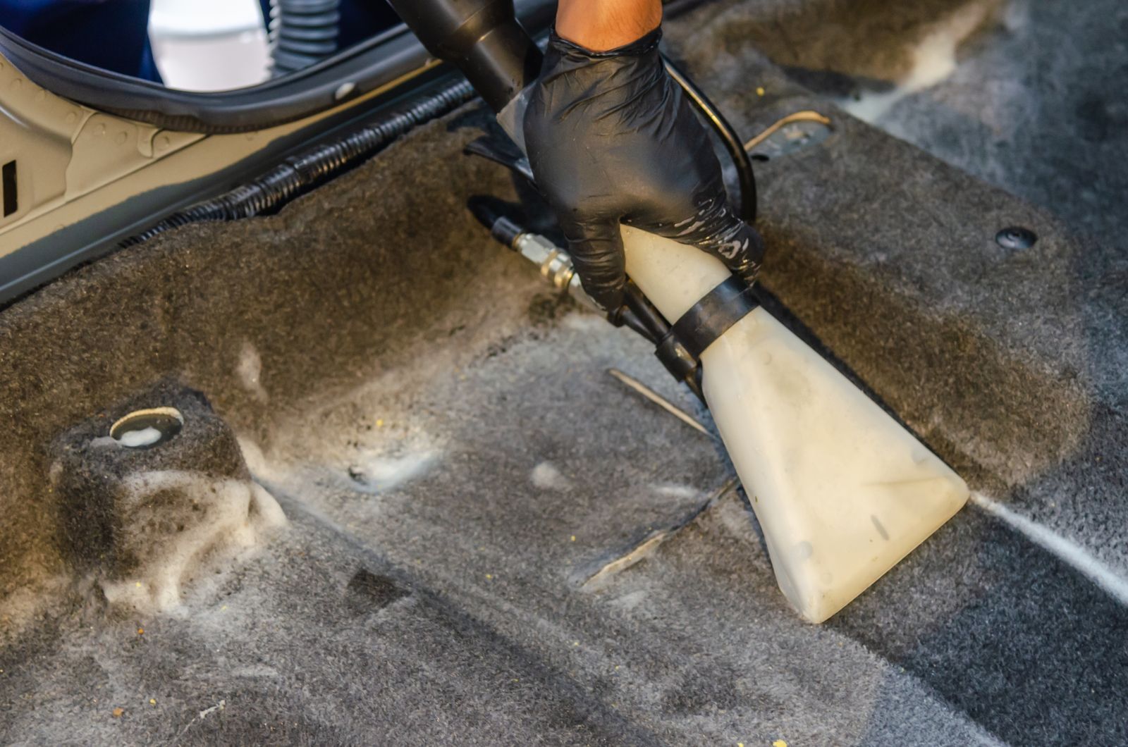 Extraction nozzle lifting dirt from car carpet