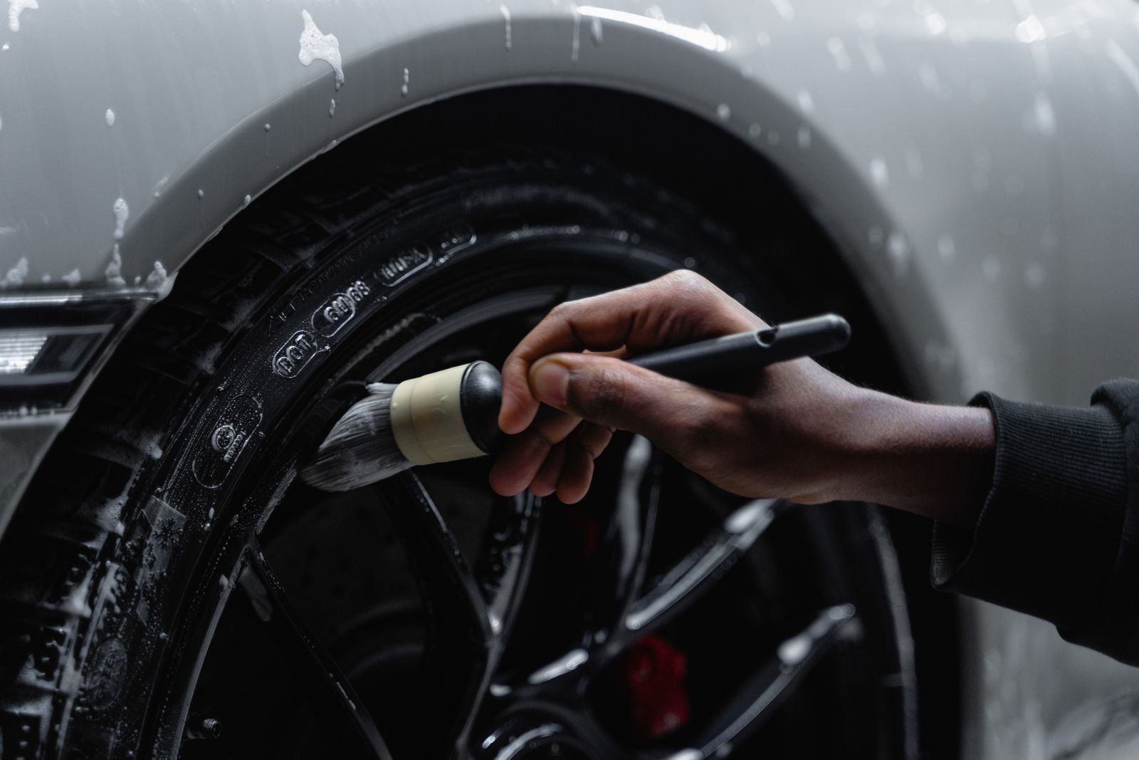A soft detailing brush cleaning a tyre and wheel