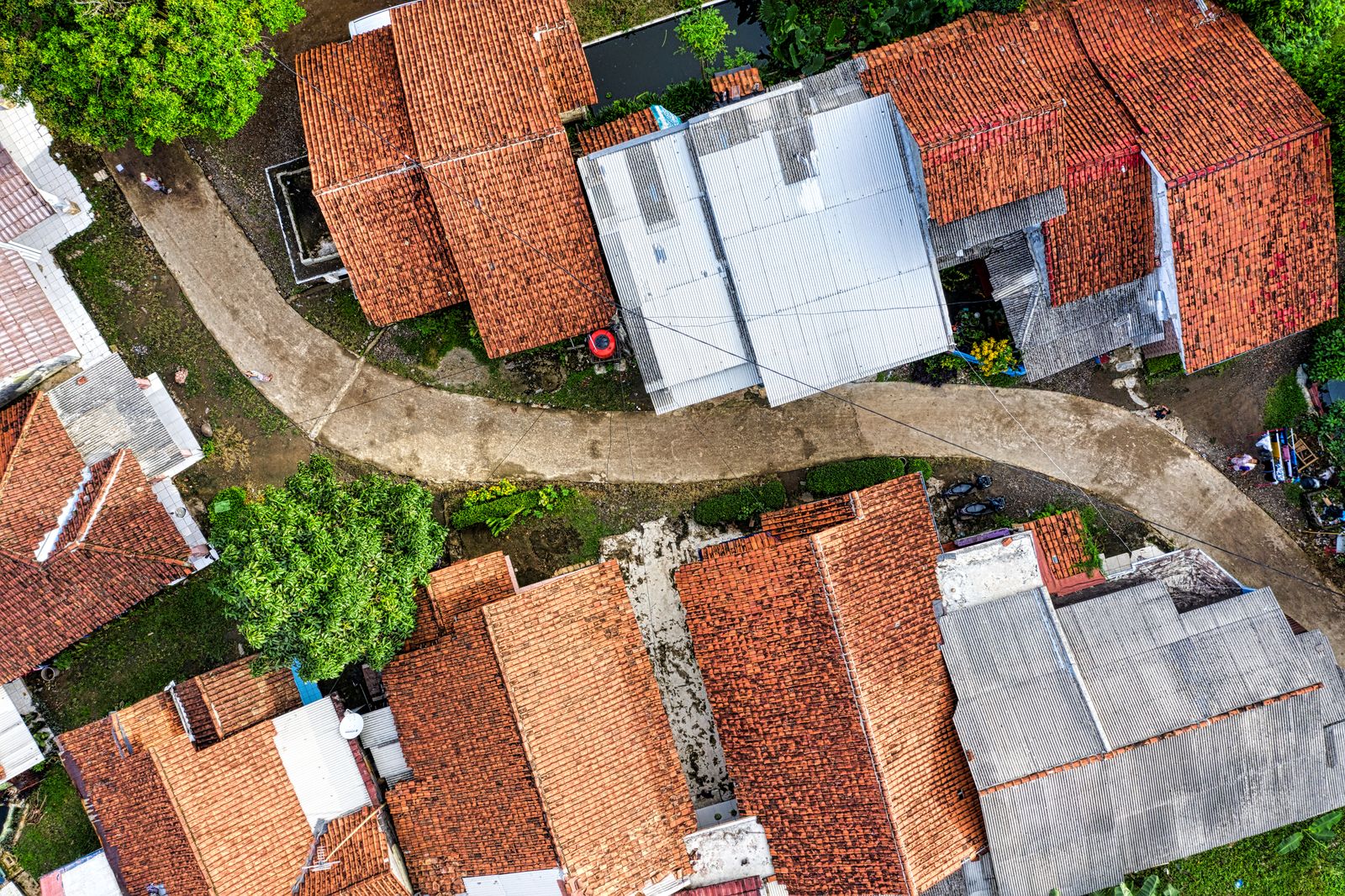 Red tiled roofs and a garden path seen from a drone