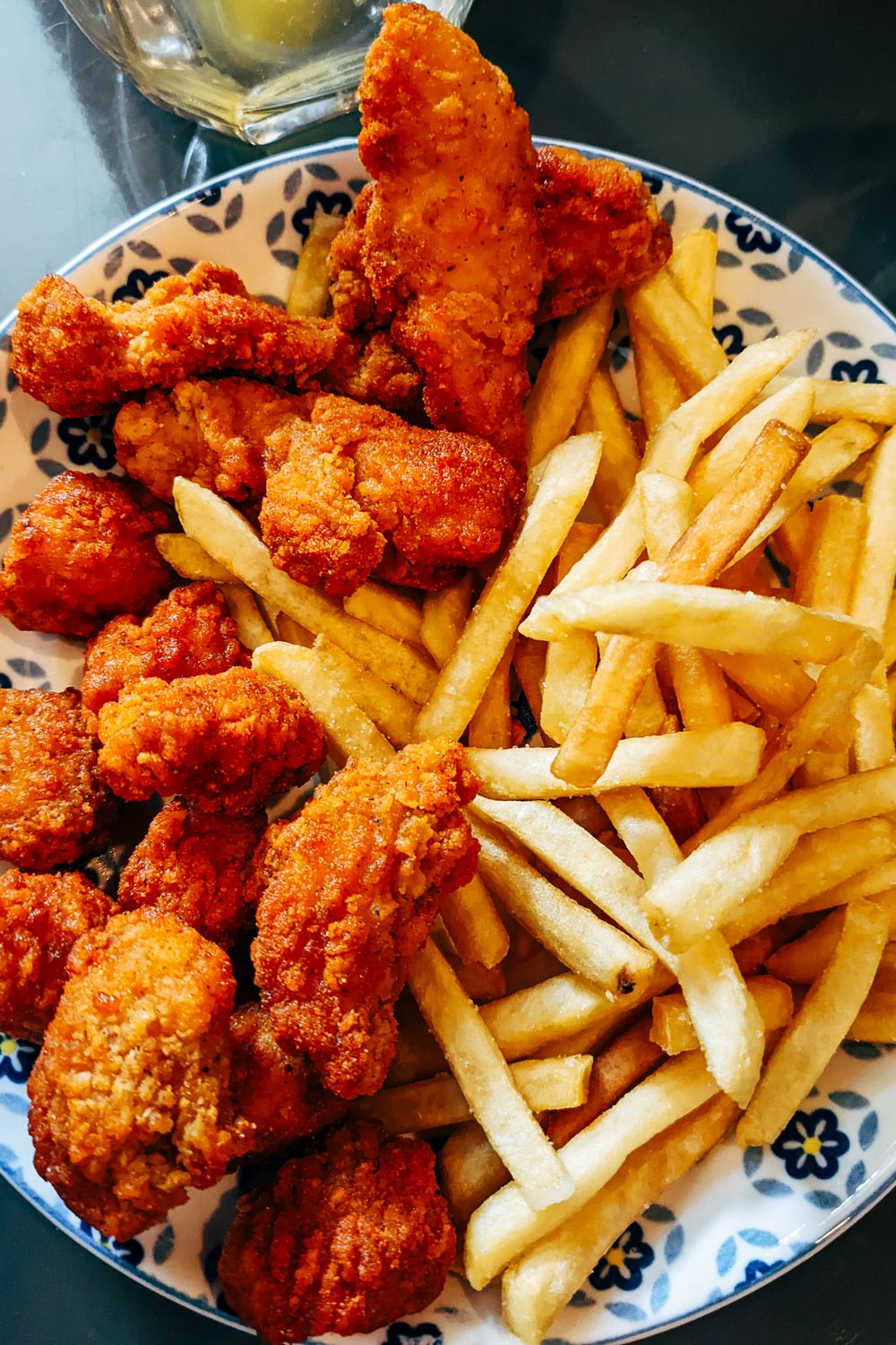 Crispy fried chicken pieces and golden fries piled on a plate