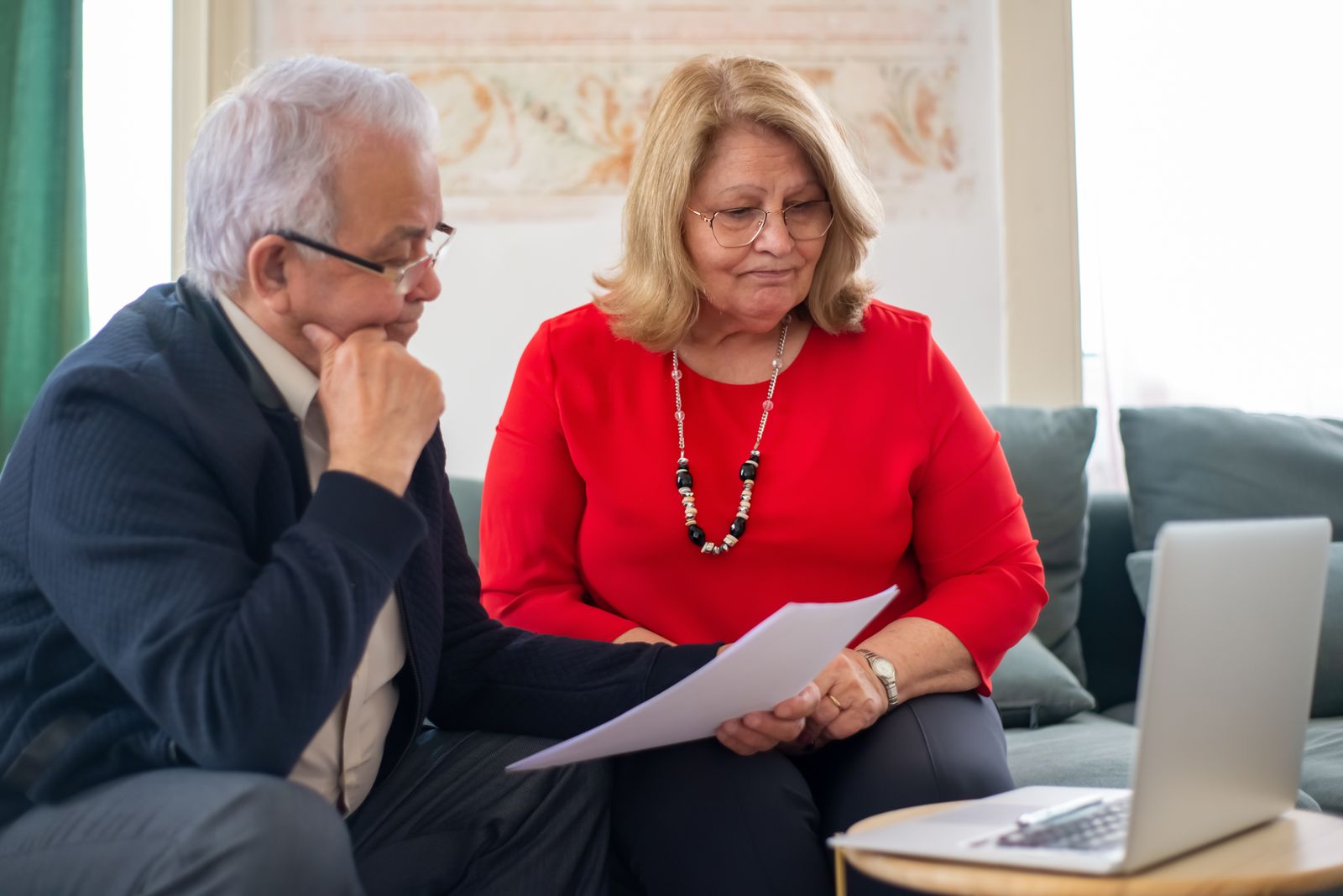 An older couple reading through financial papers together at home