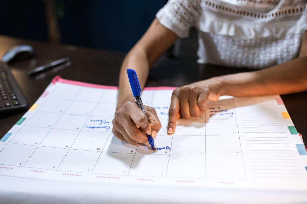 A woman marking dates on a desk calendar