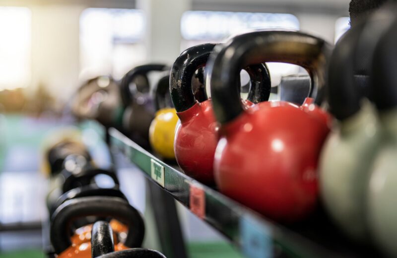 Coloured kettlebells lined up on a rack