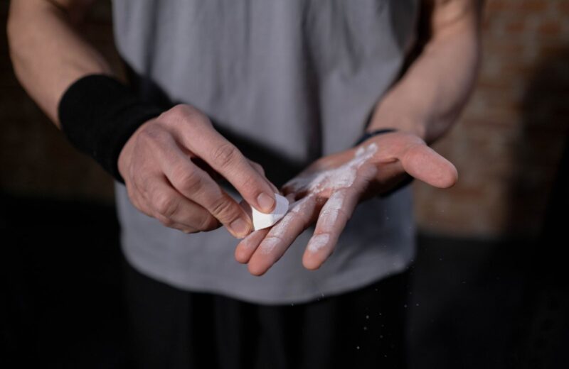 Hands rubbing a block of lifting chalk before a set