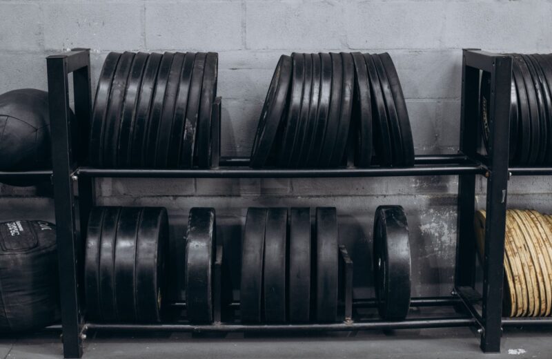 Rows of black bumper plates stored on a rack