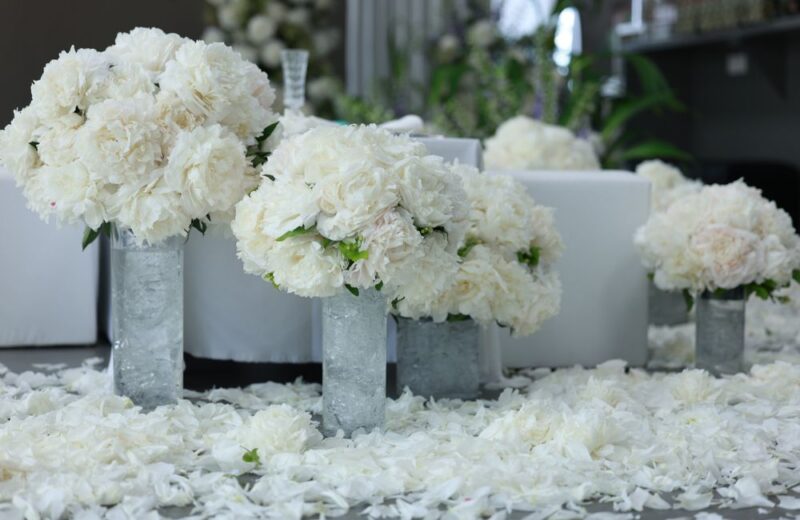 White peony arrangements in silver vases set out for a wedding