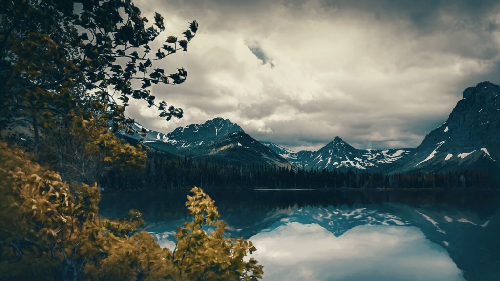 Mountains and dramatic clouds reflected in a still lake