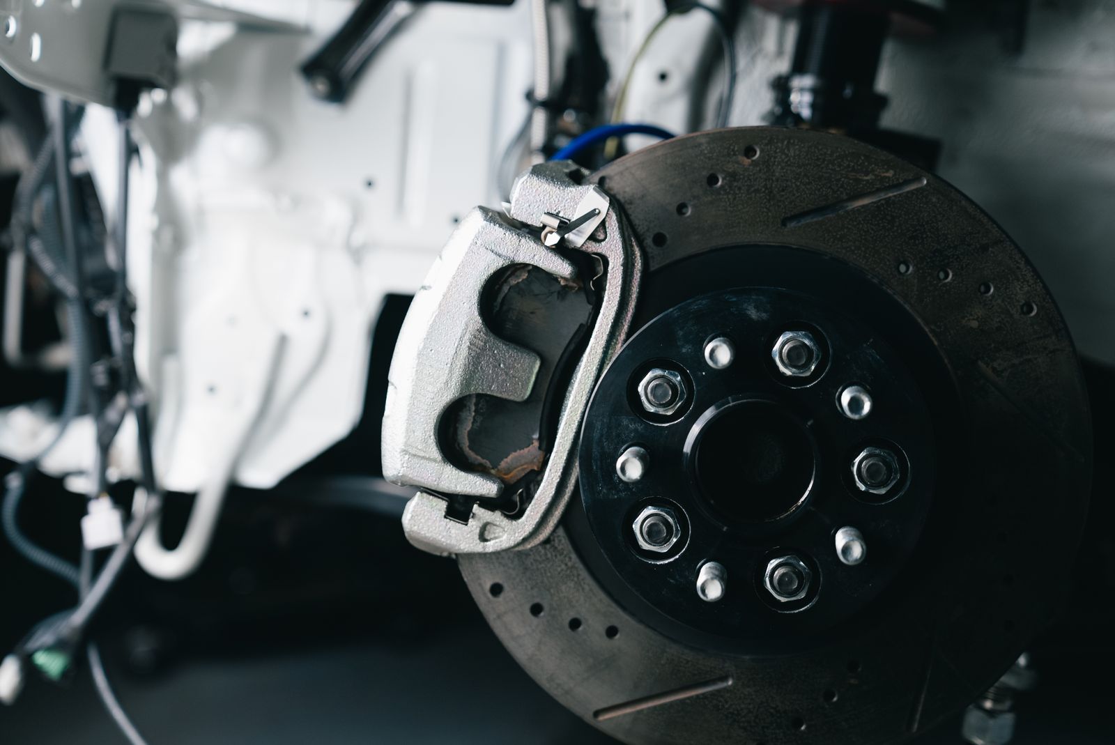 A brake disc and caliper on a car with the wheel removed
