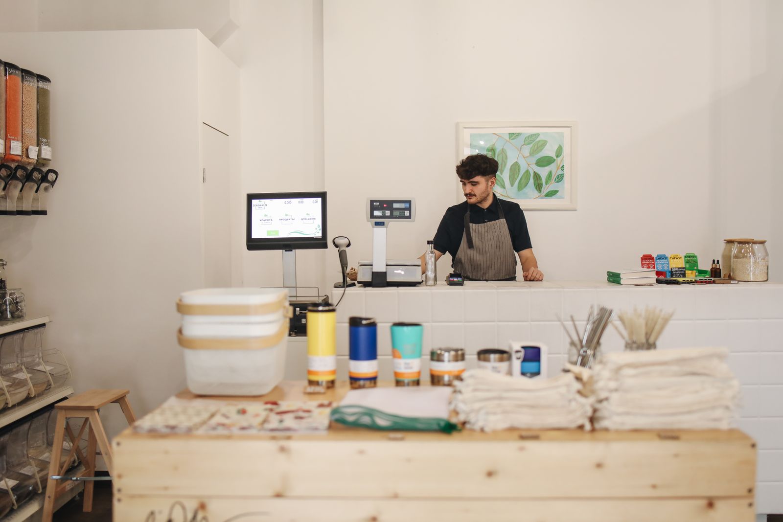 Shop owner standing behind the counter of a small refill store