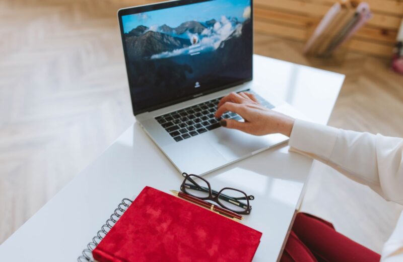 Laptop, notebook and glasses on a white table