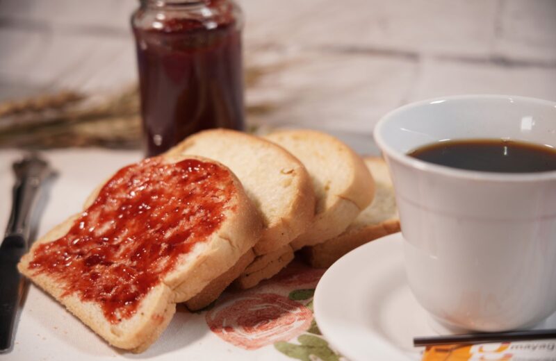 Toast with strawberry jam and a cup of black coffee