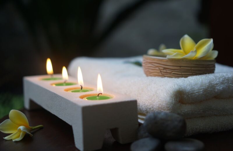 Candles, white towels and flowers in a spa room