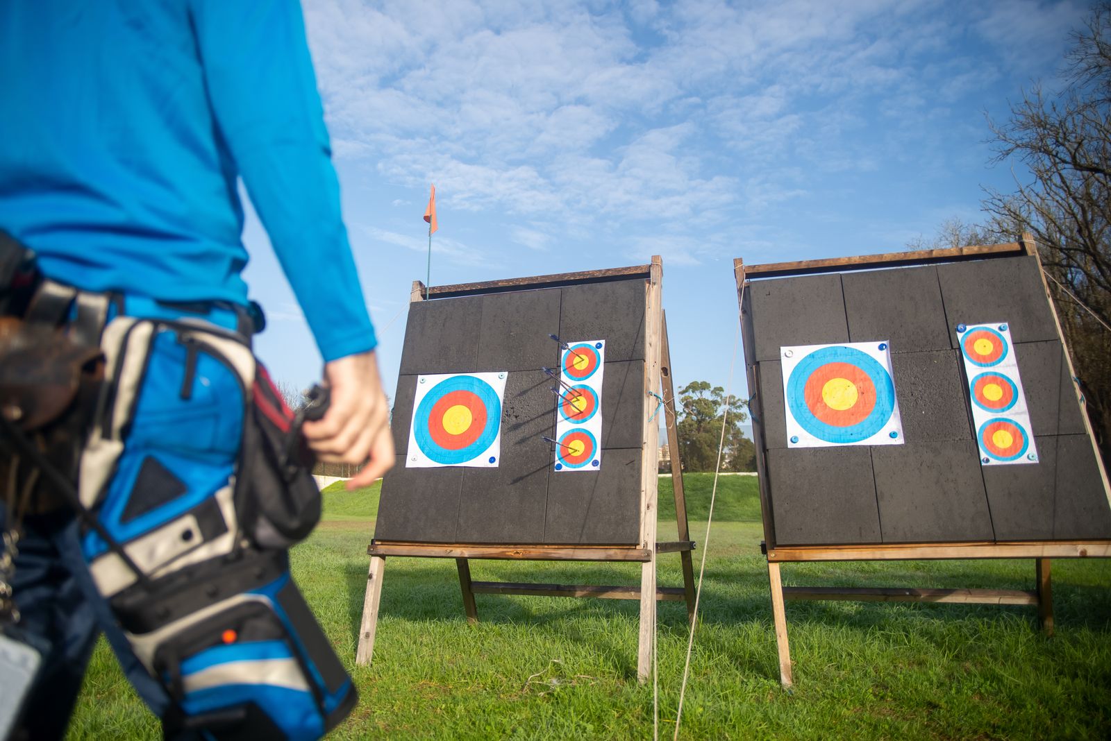 An archer by a row of targets at an outdoor practice range