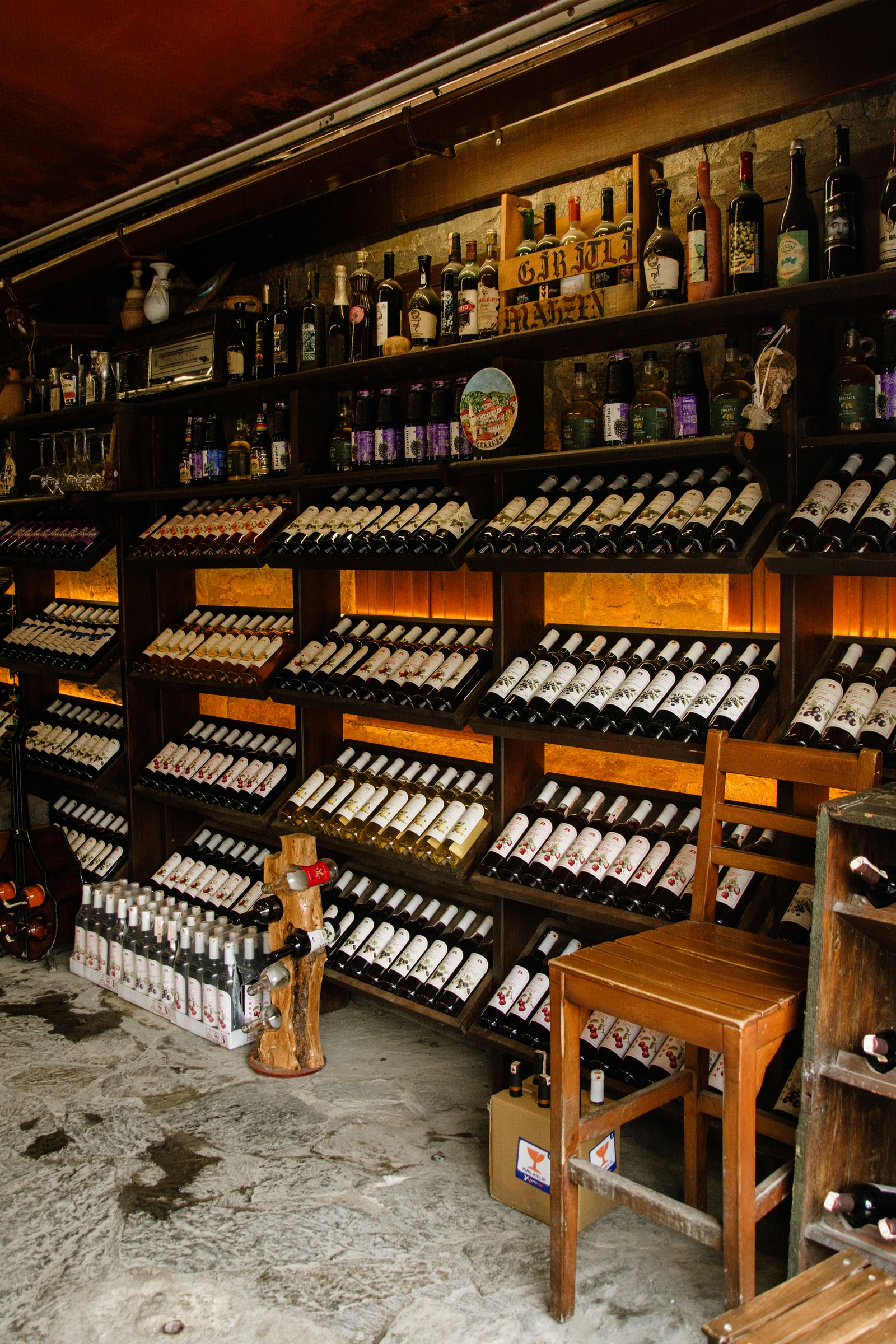 Rows of wine bottles lying in wooden racks in a warm-lit cellar